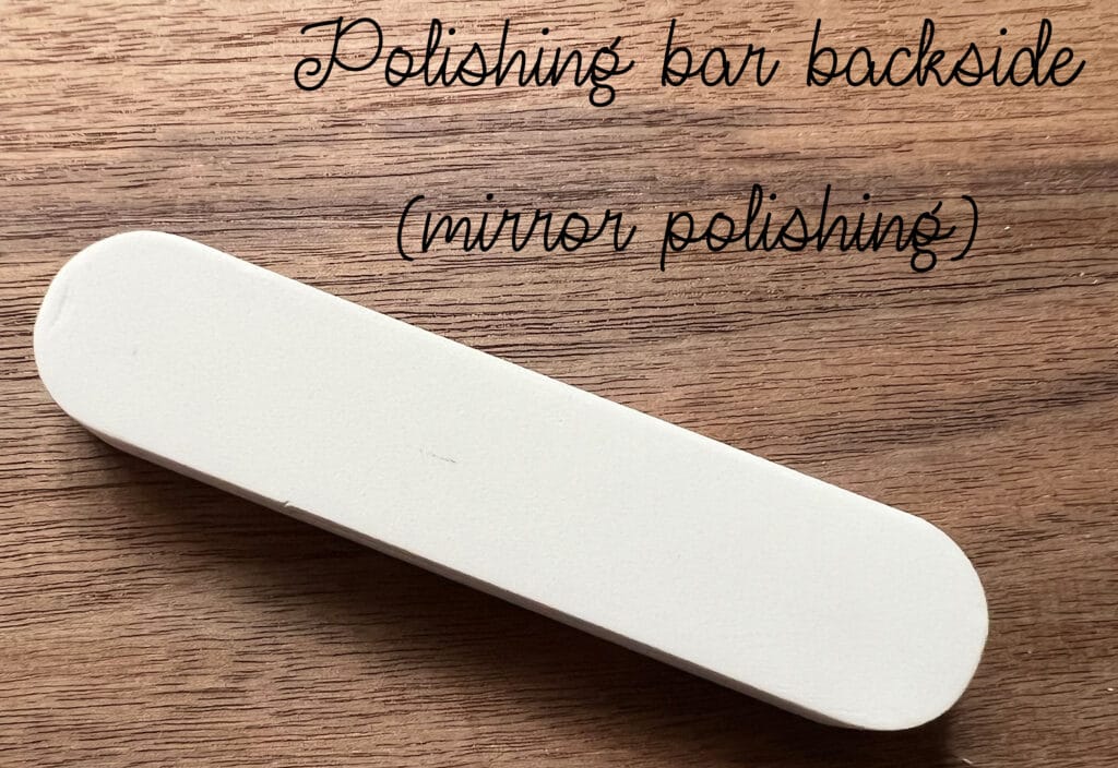 Rectangular white polishing bar on a wooden surface, labeled Polishing bar backside (mirror polishing).