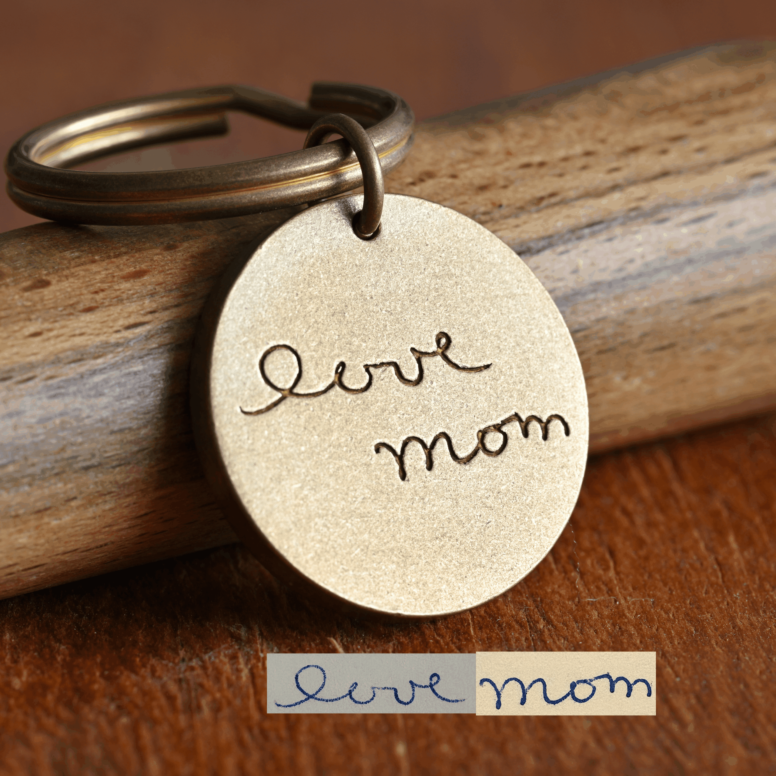 Engraved keychain with love mom script on wood surface, sentimental gift for mothers.