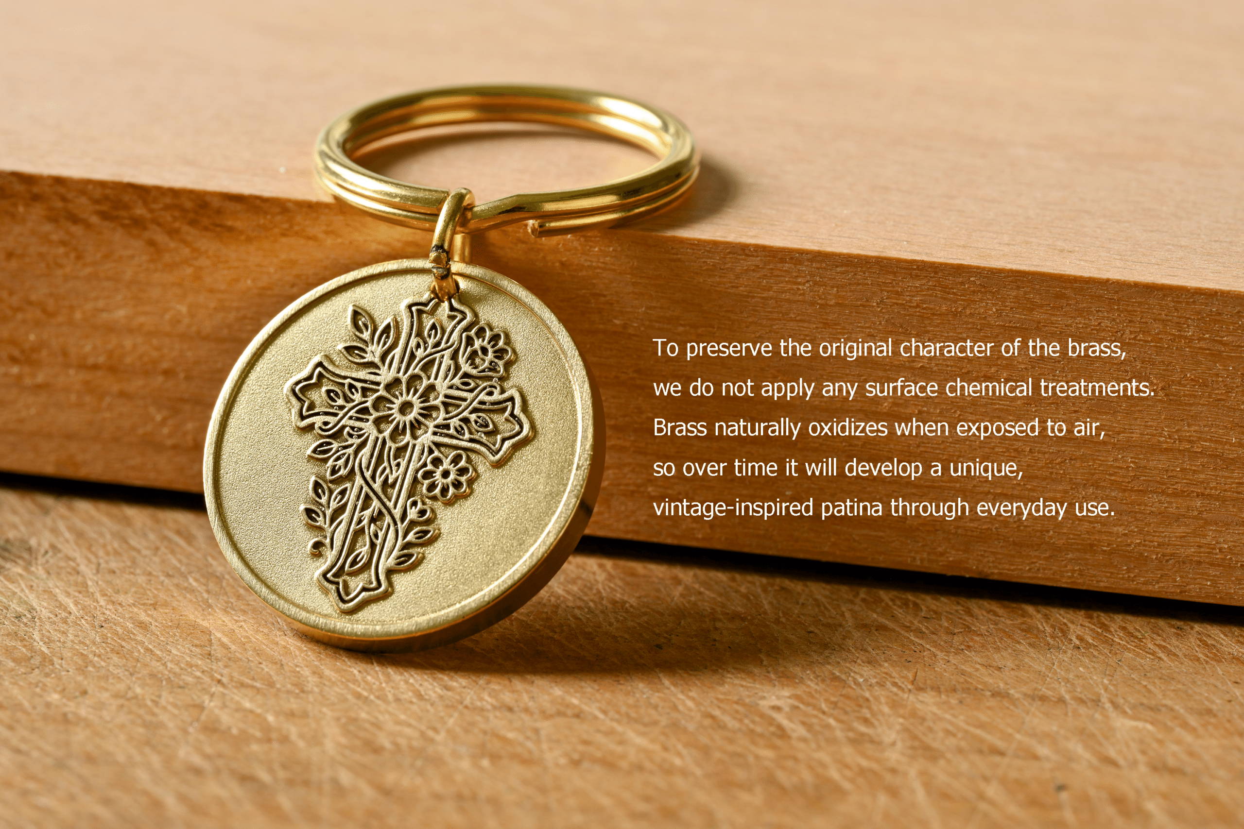 Brass keychain with a floral cross pendant. Text: Untreated brass naturally oxidizes to develop a unique patina over time