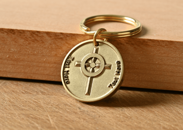 Circular gold keychain featuring a cross design and placeholder text on a wooden surface