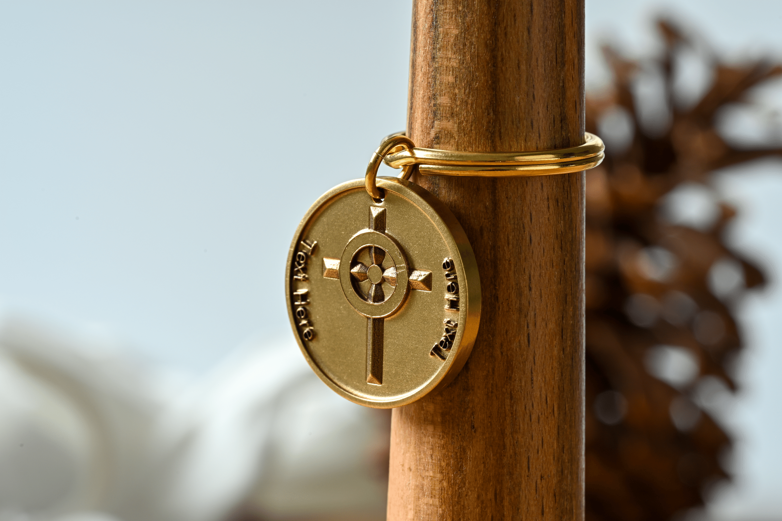 Gold circular keychain featuring a central cross design and customizable text placeholders on each side