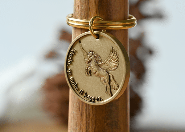Gold keychain tag featuring a Pegasus and the engraved text: Marla, go make it happen