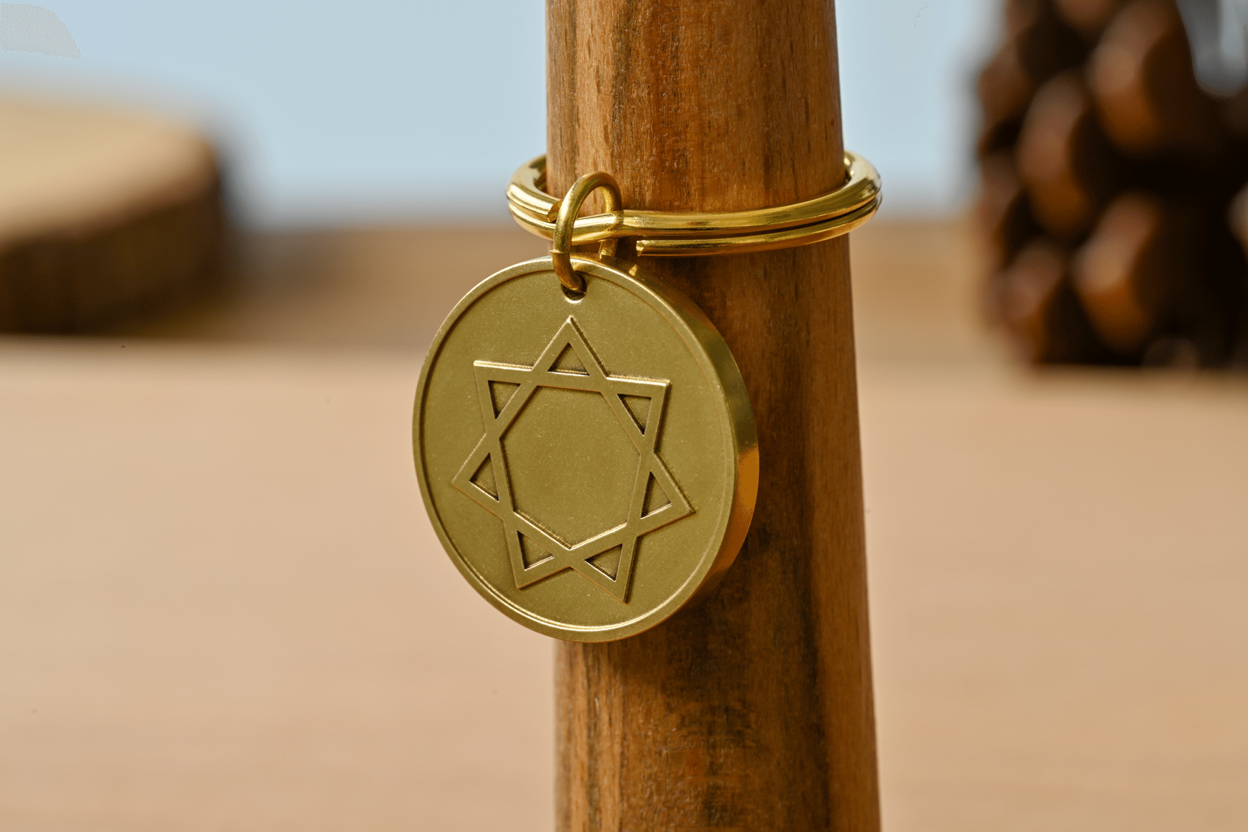 Round gold keychain featuring an engraved seven-pointed star