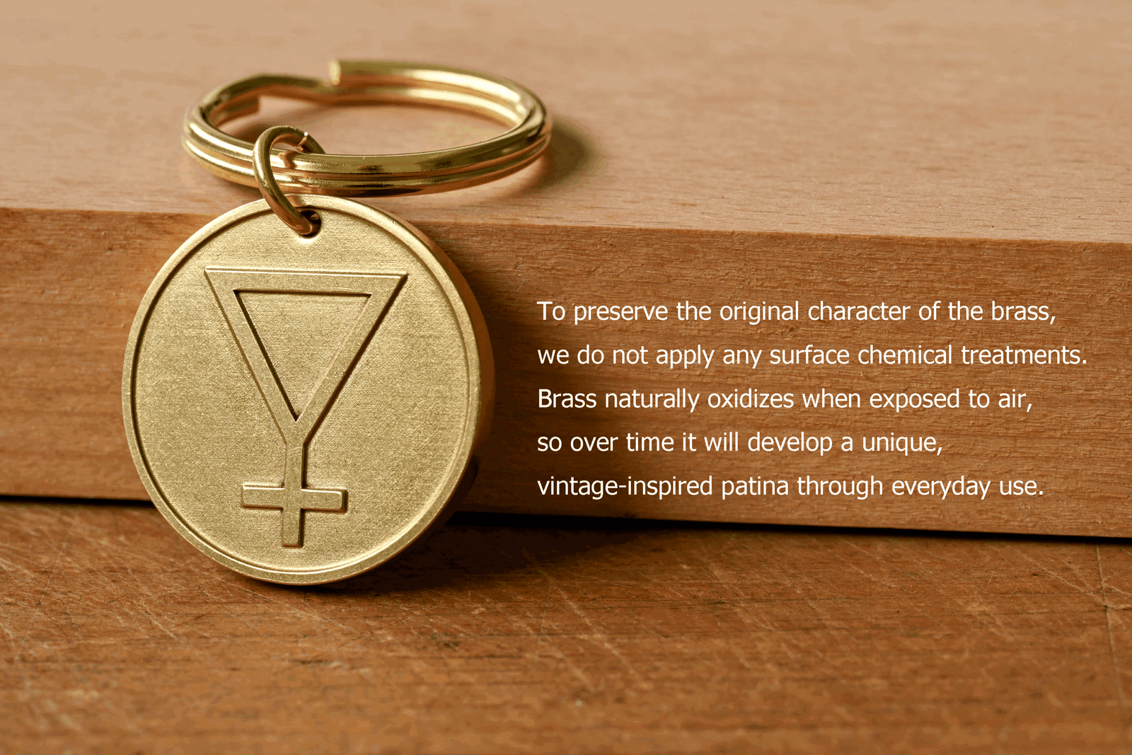 Brass keychain with an engraved symbol beside text: To preserve the original character of the brass, we do not apply any surface chemical treatments. Brass naturally oxidizes when exposed to air, so over time it will develop a unique, vintage-inspired patina through everyday use