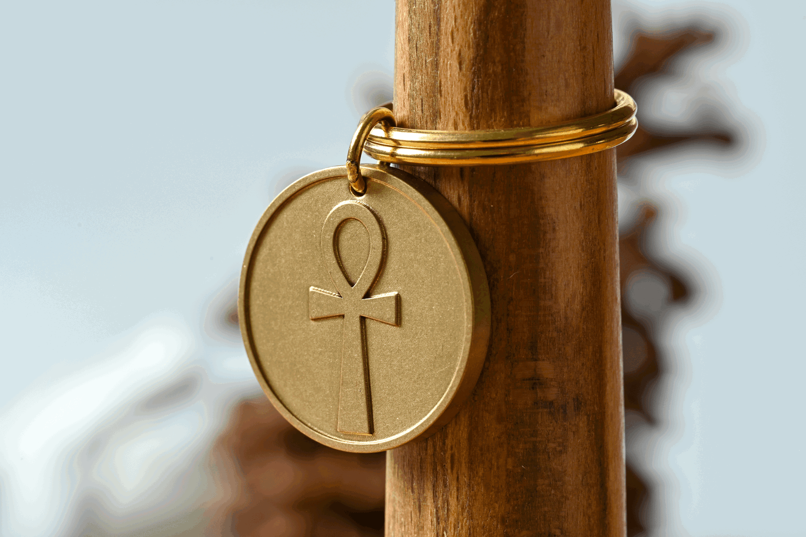 Gold circular keychain featuring an embossed Egyptian ankh symbol