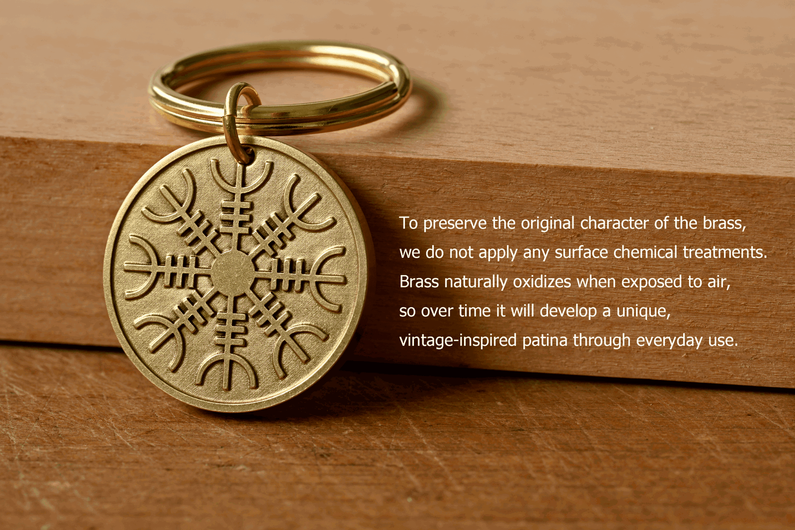Brass keychain with an engraved Norse symbol next to text: To preserve the original character of the brass, we do not apply any surface chemical treatments. Brass naturally oxidizes when exposed to air, so over time it will develop a unique, vintage-inspired patina through everyday use
