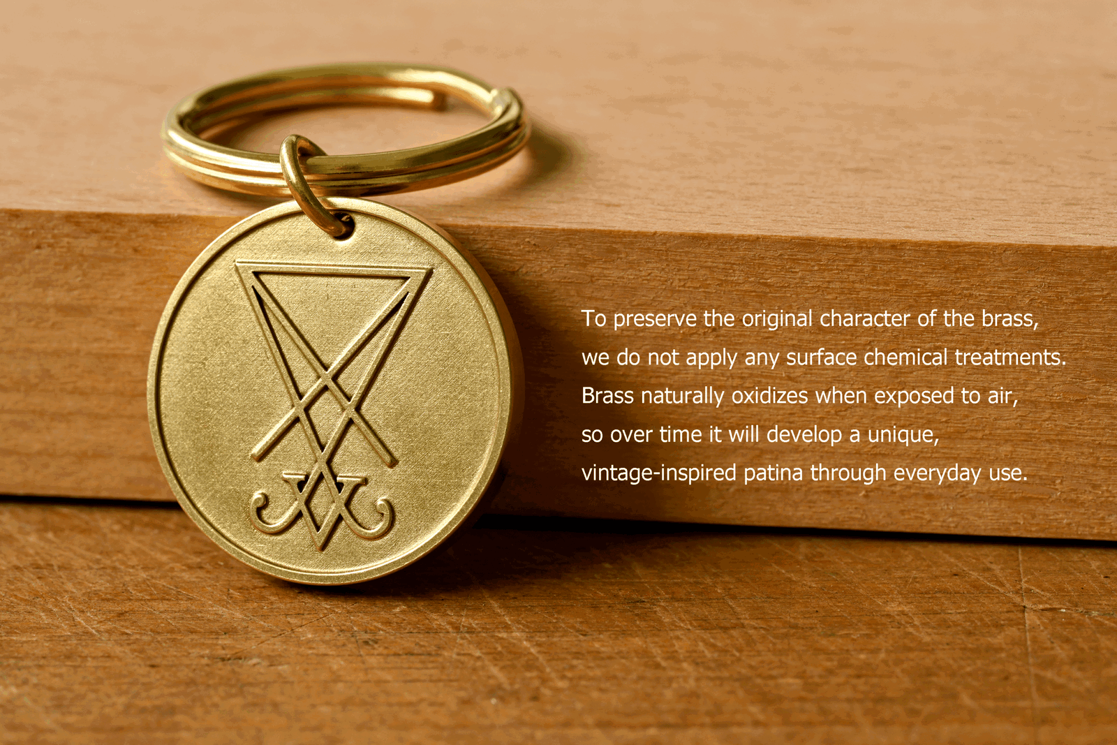 Brass key ring tag engraved with the Sigil of Lucifer. Text reads: To preserve the original character of the brass, we do not apply any surface chemical treatments. Brass naturally oxidizes when exposed to air, so over time it will develop a unique, vintage-inspired patina through everyday use