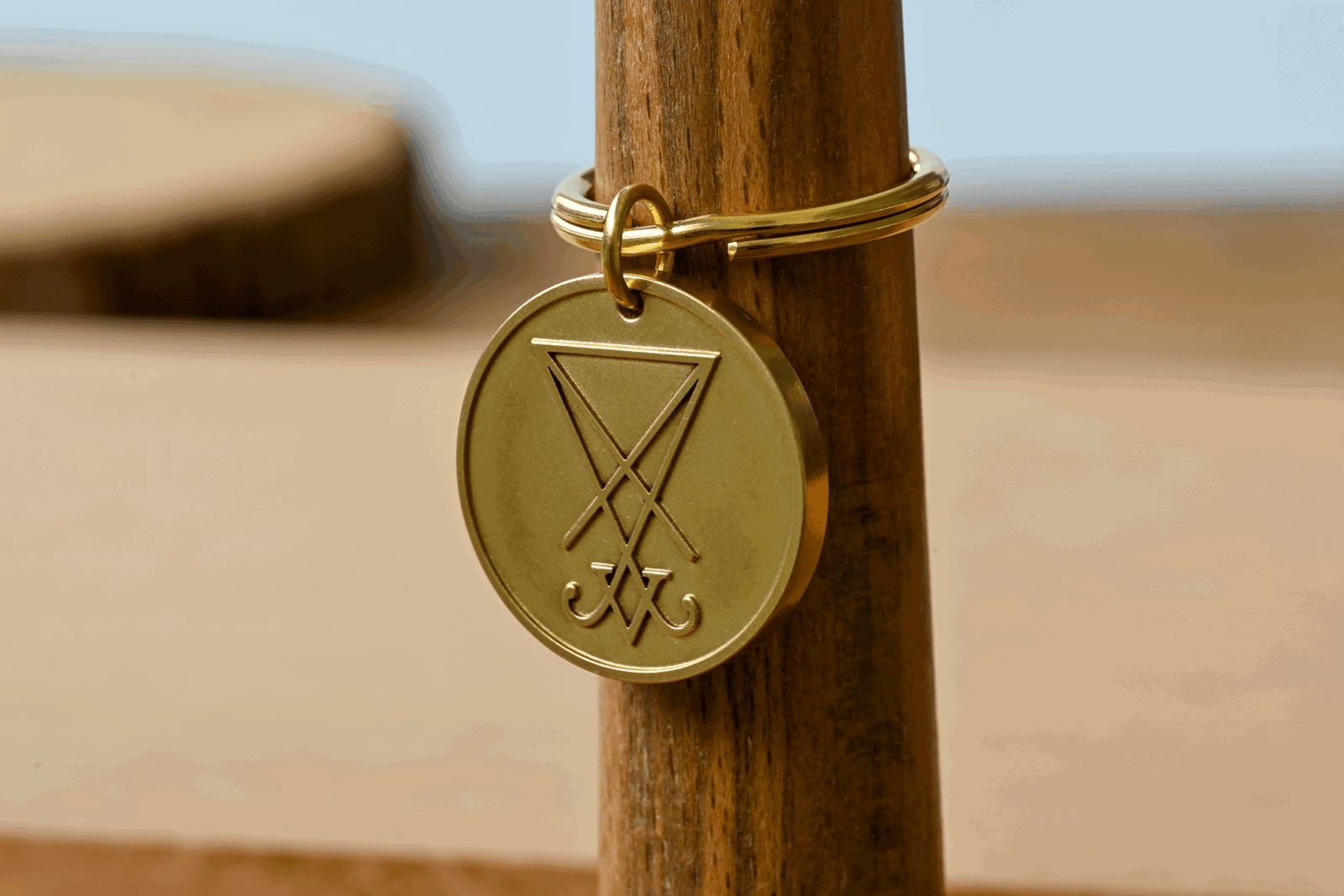 Gold keychain featuring a round medallion engraved with the Sigil of Lucifer