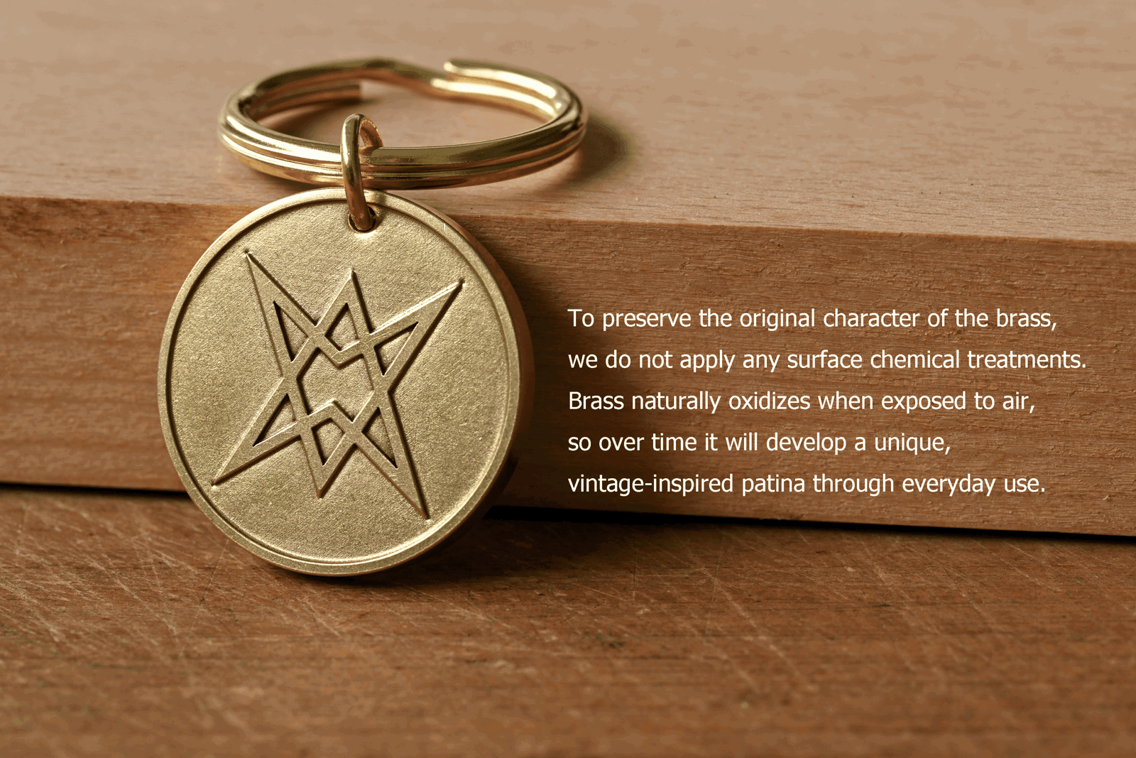 Brass keychain featuring an engraved unicursal hexagram, next to text: To preserve the original character of the brass, we do not apply any surface chemical treatments. Brass naturally oxidizes when exposed to air, so over time it will develop a unique, vintage-inspired patina through everyday use
