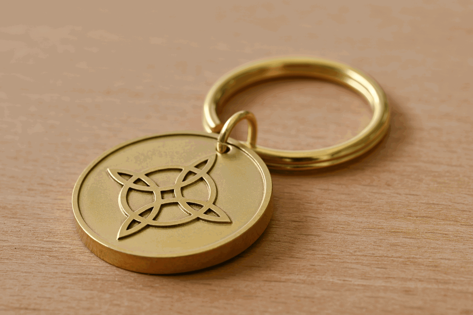 Brass keychain with a circular pendant featuring a Celtic knot on a wooden surface